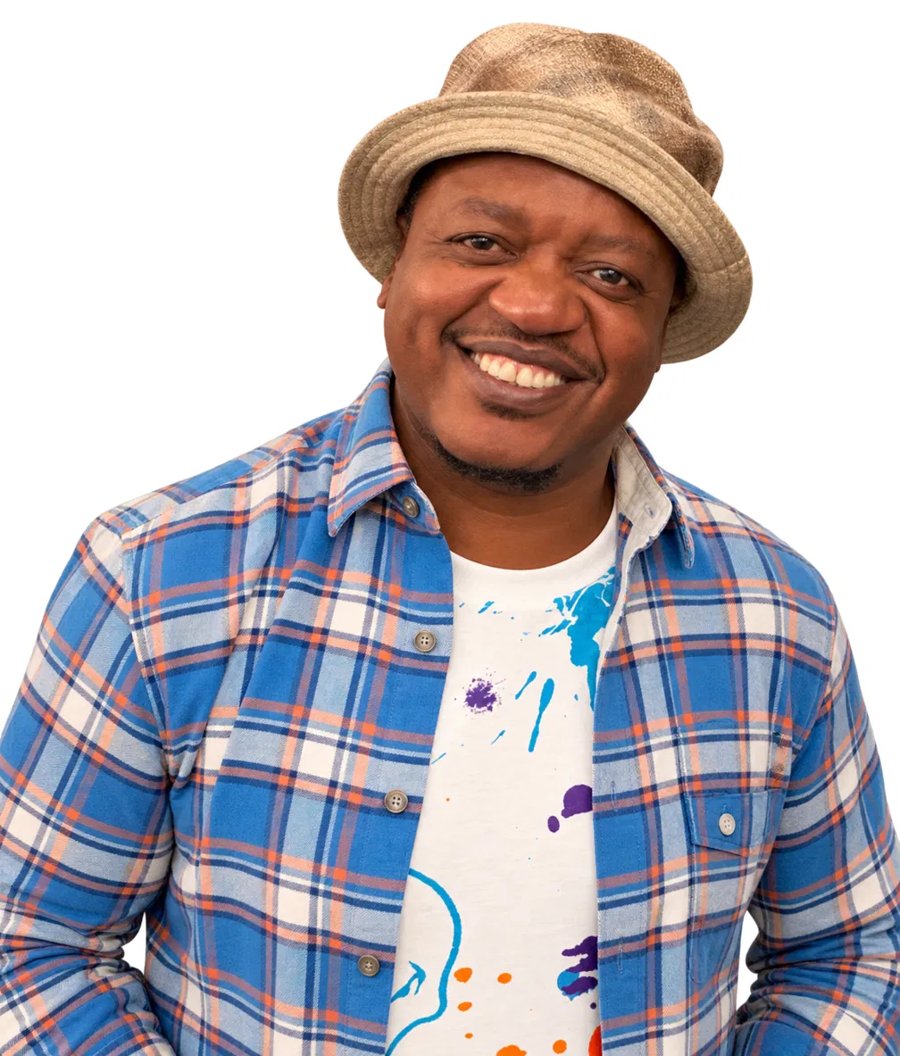 Portrait of Clayton Pasi Gunguwo, smiling, in a tan bucket hat and blue plaid shirt